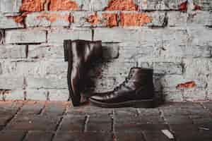 Free photo a closeup of a pair of classic shoes on a brick wall