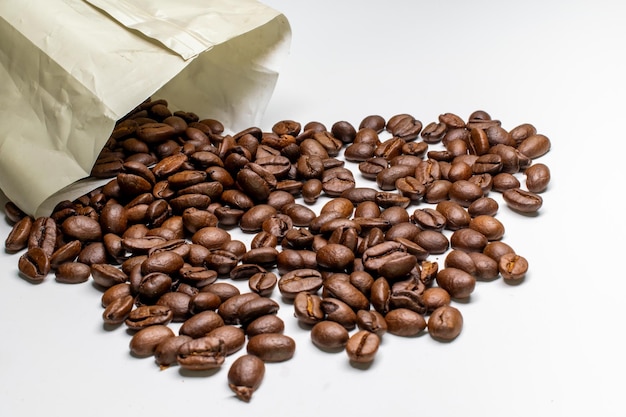 Closeup of a paper bag with roasted coffee beans under the lights isolated on a white background