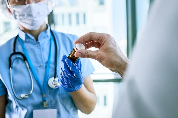 Closeup of patient receiving antiviral drugs from a doctor during coronavirus pandemic