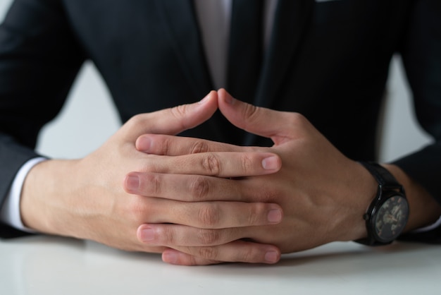 Foto gratuita primo piano dell'imprenditore pensoso con le mani clasped