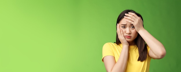 Closeup perplexed devastated distressed cute young teenage girl worrying passing exam grab head face