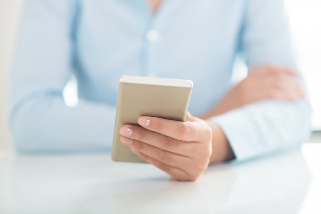 Closeup of person networking on smartphone at table