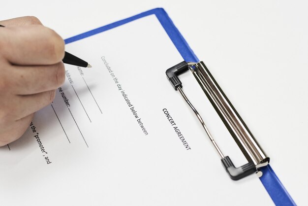 Closeup of a person signing a concert agreement