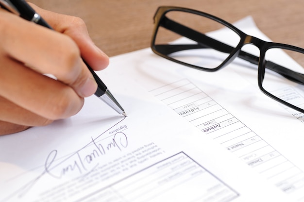 Closeup of person signing document