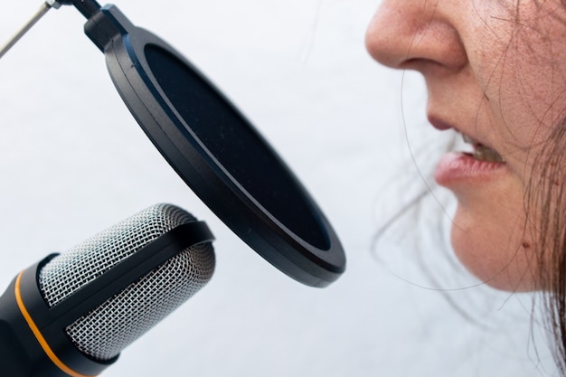 Free photo closeup of a person taking on black and grey microphone captured on a white background