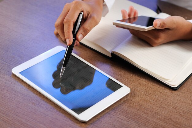 Closeup of person working and using tablet and smartphone