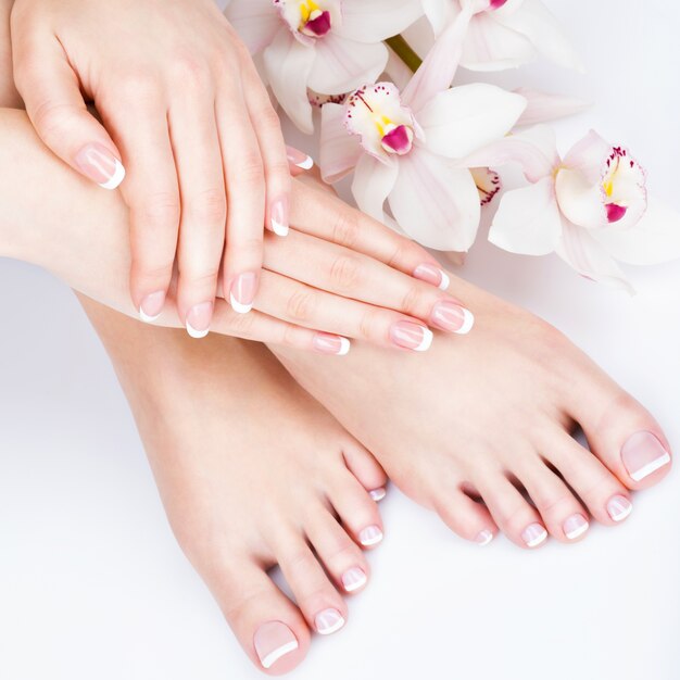 Closeup photo of a female feet at spa salon on pedicure and manicure procedure - Soft focus image