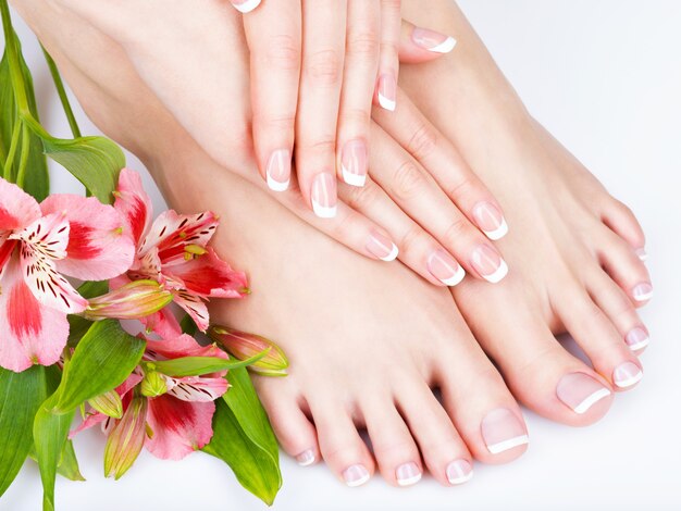 Closeup photo of a female feet at spa salon on pedicure and manicure procedure - Soft focus image