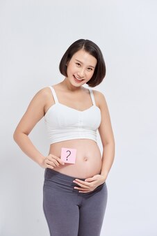 腹​の​ポストイットステッカー​に​描かれた​疑問符​で​妊娠中​の​クローズアップ​写真