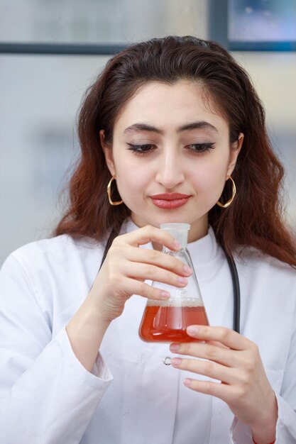 화학 병을 킁킁 거리는 젊은 여성 의사의 근접 촬영 사진 고품질 사진