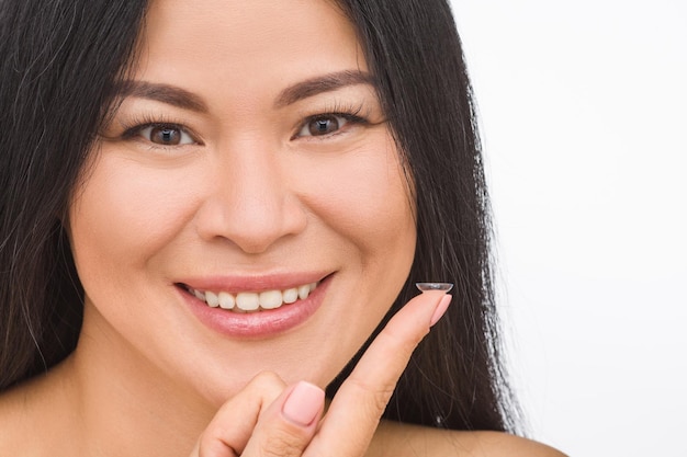 Closeup picture of pretty Korean or Asian woman with contact lenses isolated on white backgroind in studio.