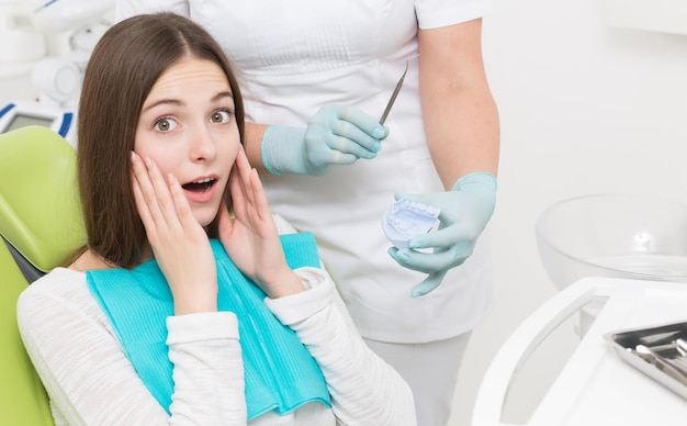 Maschera del primo piano della giovane donna che tocca le sue guance. giovane donna che ha problemi con i denti