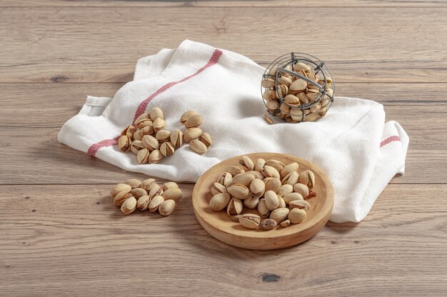 Closeup of pistachios in small containers on a wooden table