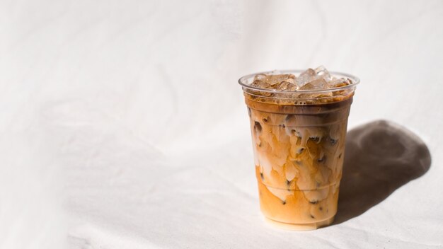Download Premium Photo Closeup Plastic Cup Of Iced Coffee With Milk On The Table