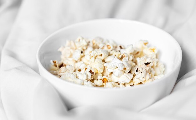 Closeup of a plate of popcorn in bed in the morning