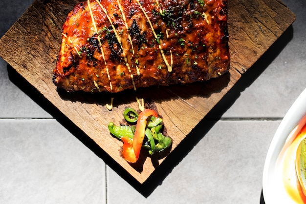 Closeup of pork ribs steak on wooden board food styling
