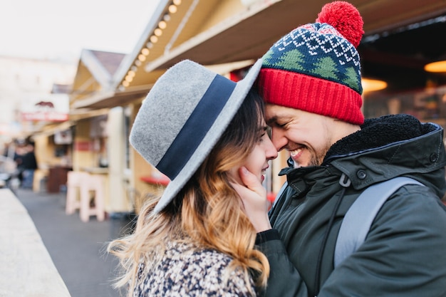 Closeup portrait amazing couple in love enjoying time together on street. True lovely emotions, brightful feelings, happiness, christmas time, falling in love.