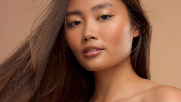 理想的なストレートの髪が吹き出すアジアのタイの日本のモデルのクローズアップの肖像画