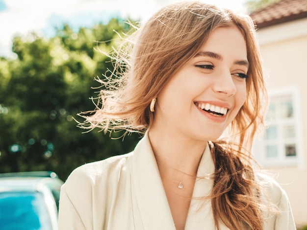 Closeup portrait of beautiful smiling brunette model. trendy female posing in the street