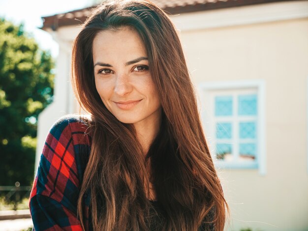 Closeup portrait of beautiful smiling brunette model. Trendy female posing in the street