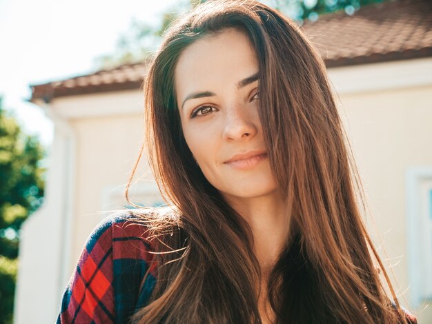 Closeup portrait of beautiful smiling brunette model. Trendy female posing in the street