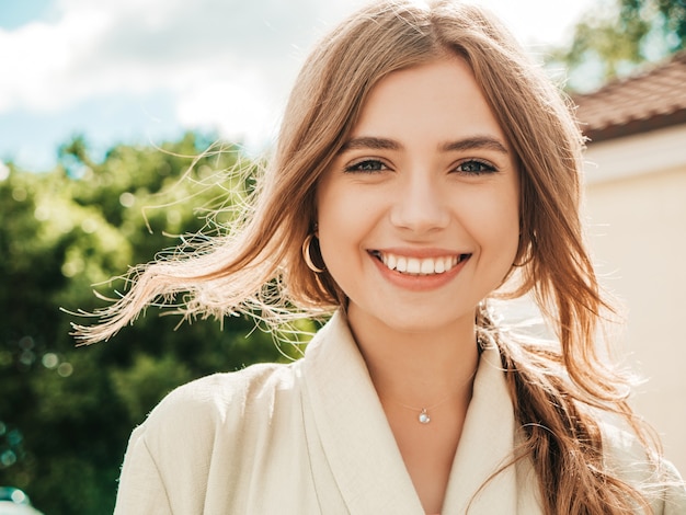 Closeup portrait of beautiful smiling brunette model. Trendy girl posing in the street 