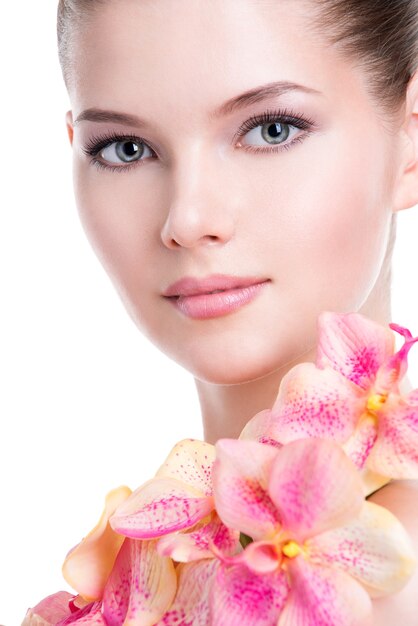 건강 한 피부와 바디-화이트 절연에 핑크 꽃 아름 다운 젊은 여자의 근접 촬영 초상화.