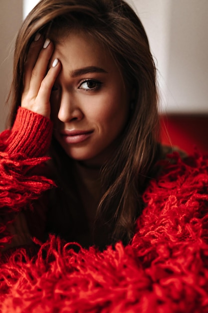 Closeup portrait of browneyed woman in knitted shaggy sweater sad looking at camera