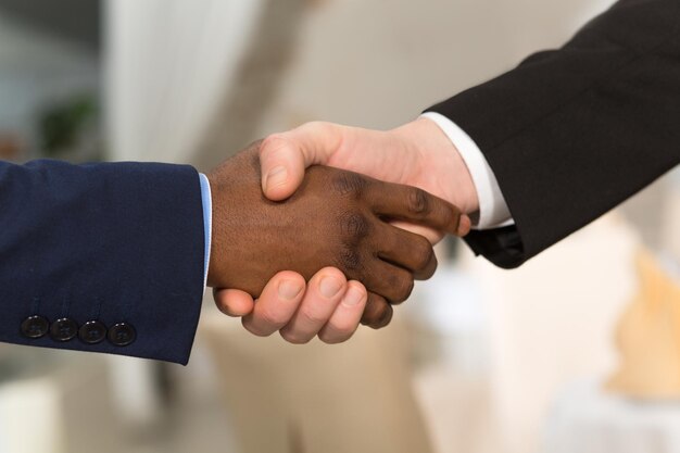 Closeup portrait of business people shaking hands People showing mutual agreement betweent their companies or enterprises