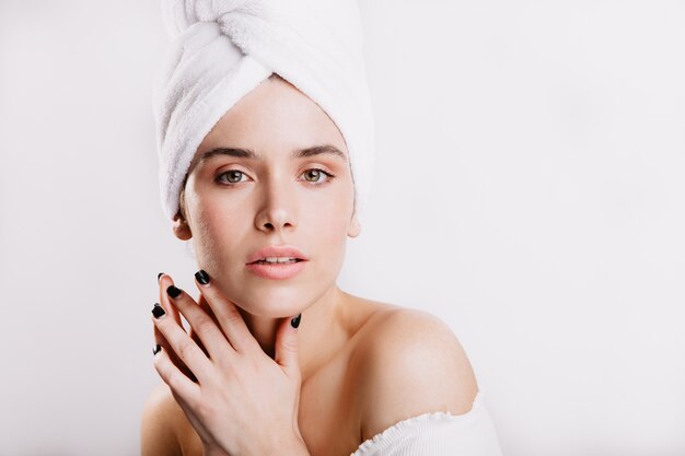 Closeup portrait of calm woman in towel after shower. Lady with green eyes and no makeup