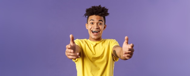 Closeup portrait of charismatic happy friendlylooking hispanic man with dreads reaching hands forwar