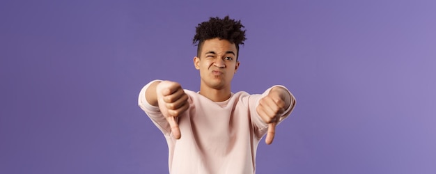 Closeup portrait of disappointed unimpressed young hispanic man with dreads grimacing skeptical judg