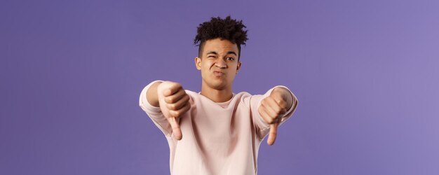 Closeup portrait of disappointed unimpressed young hispanic man with dreads grimacing skeptical judg