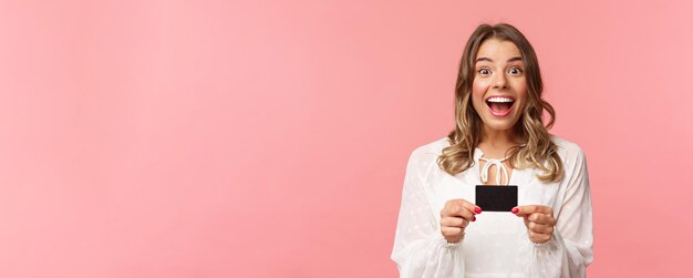 Closeup portrait of excited and happy goodlooking blond female recommend bank smiling amazed holding