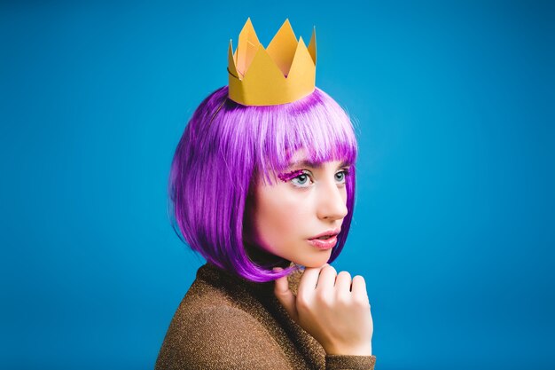 Closeup portrait fashionable young serious woman in golden crown . Cut purple hair, princess style