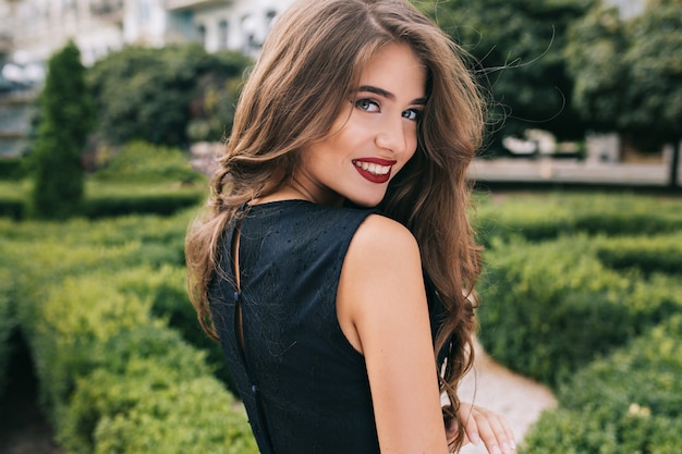 Closeup portrait from back of pretty girl with attractive makeup and red lips