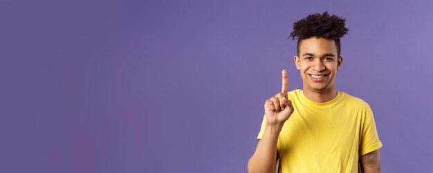 Closeup portrait of funny young teenager guy picking nose showing index finger and giggle gagging ov