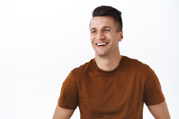 Closeup portrait of handsome happy guy looking away at blank white space smiling pleased and enthusiastic seeing good choice or opportunity concept of advertisement and recommendation