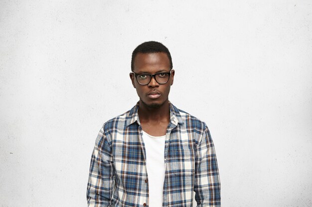 Closeup portrait of handsome, smart and self-confident young black male with serious face expression