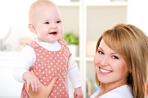 Closeup portrait of  happy mother with newborn baby - indoors