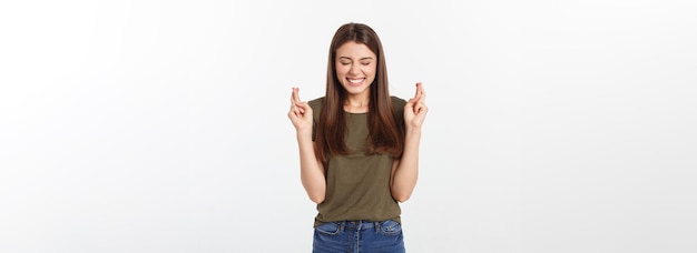 Closeup portrait hopeful beautiful woman crossing her fingers open eyes hoping asking best isolated