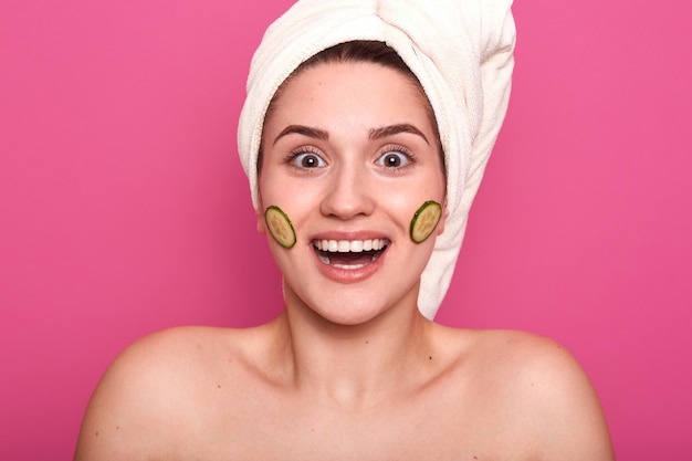 Closeup portrait of impressed satisfied smiling woman standing naked isolated over pink