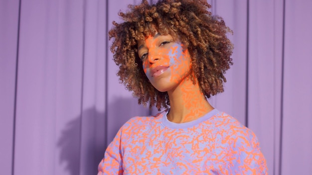 Closeup portrait of mixed race woman with neon makeup poses to the camera new beauty concept authentic identity