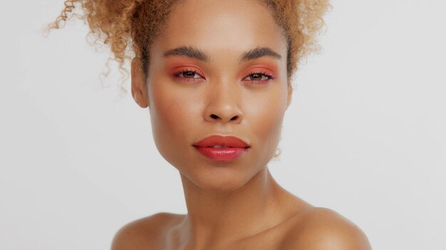 Closeup portrait of mixed rase woman with red makeup in studio calm watching to the camera