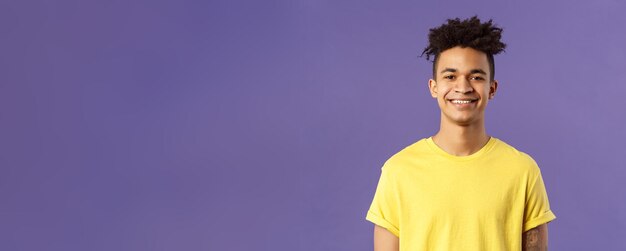 Крупным планом портрет симпатичного дружелюбно выглядящего латиноамериканского студента в желтой футболке, ухмыляющегося в восторге