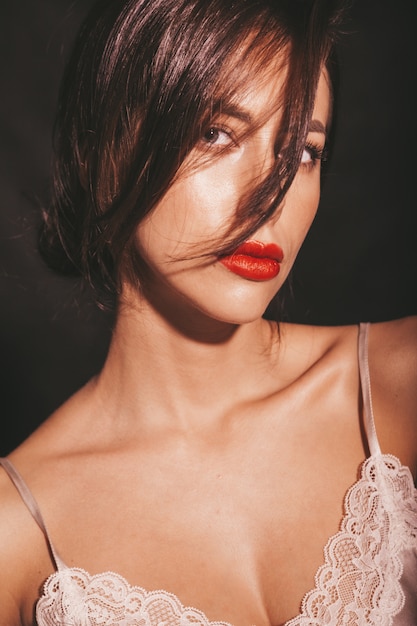 Бесплатное фото Портрет крупного плана красивой чувственной женщины брюнет. девушка в элегантной бежевой классической одежде. модель с красными губами, сложенные