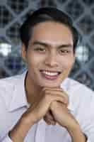 무료 사진 웃 고있는 젊은 아시아 남자의 클로 우즈 업 초상화