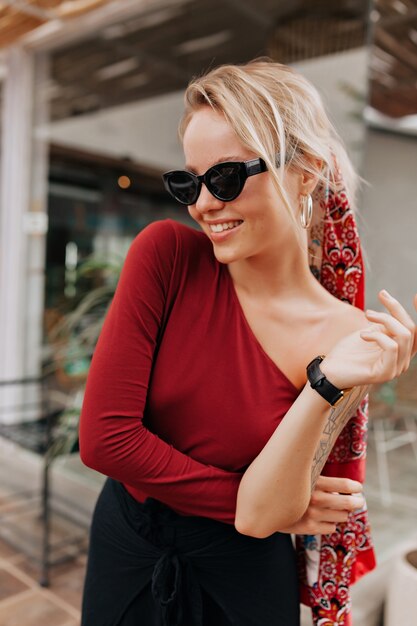 Closeup portrait of pretty girl with long blonde hair in the street