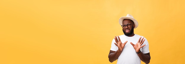 Closeup portrait of shocked mad young man raising hand up to say no stop right there isolated on yel