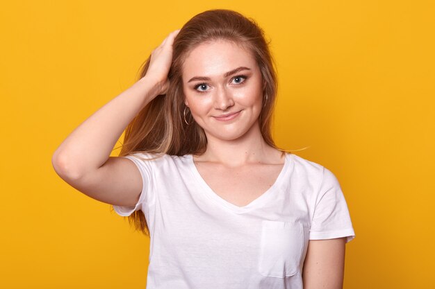 Closeup portrait of sincere energetic blond haired girl having calm look